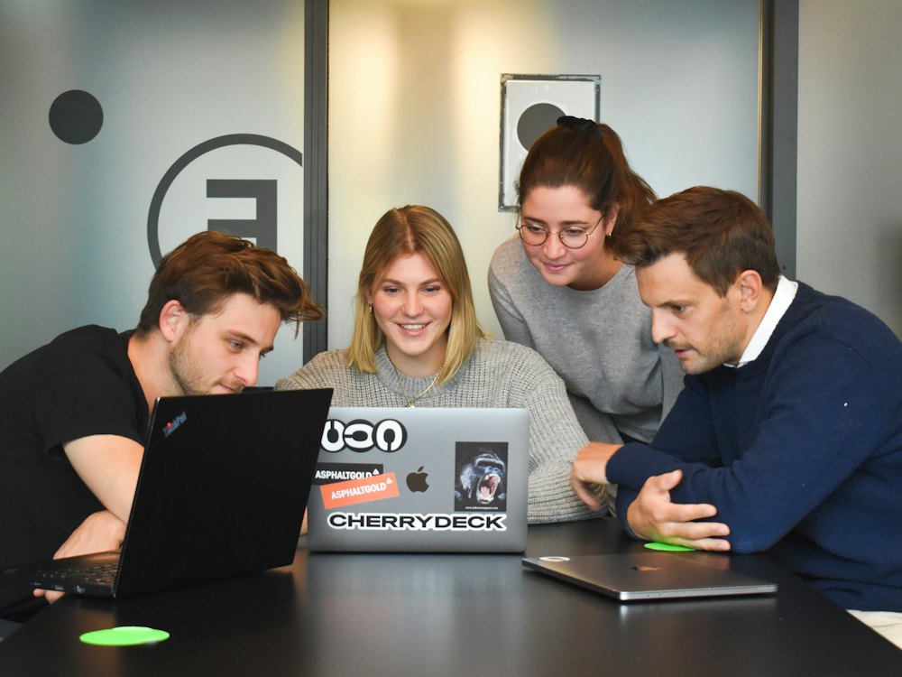 Team di lavoro in ufficio attorno ai portatili